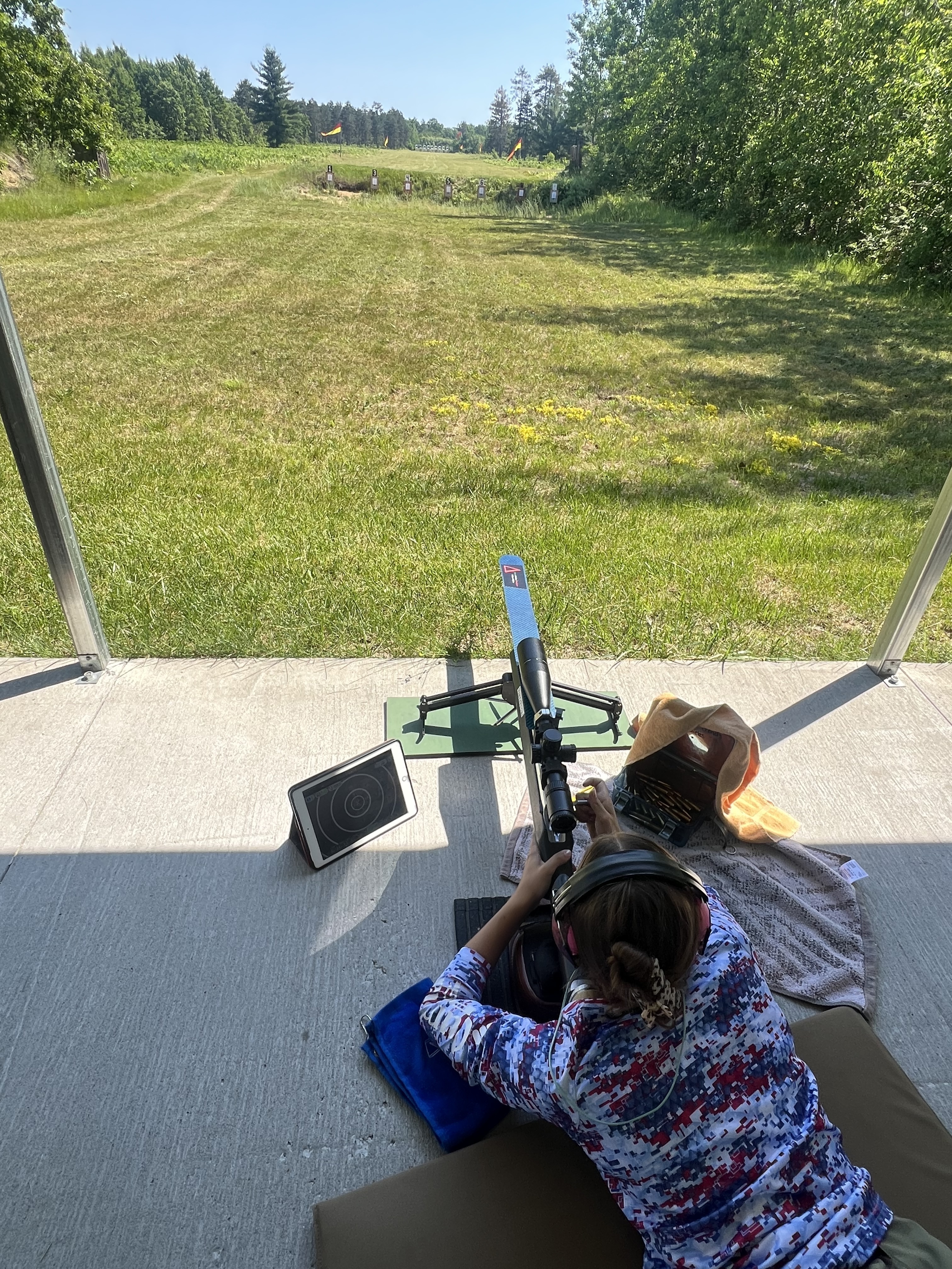 Sydnie shooting from the prone position on a range with electronic scoring equipment nearby